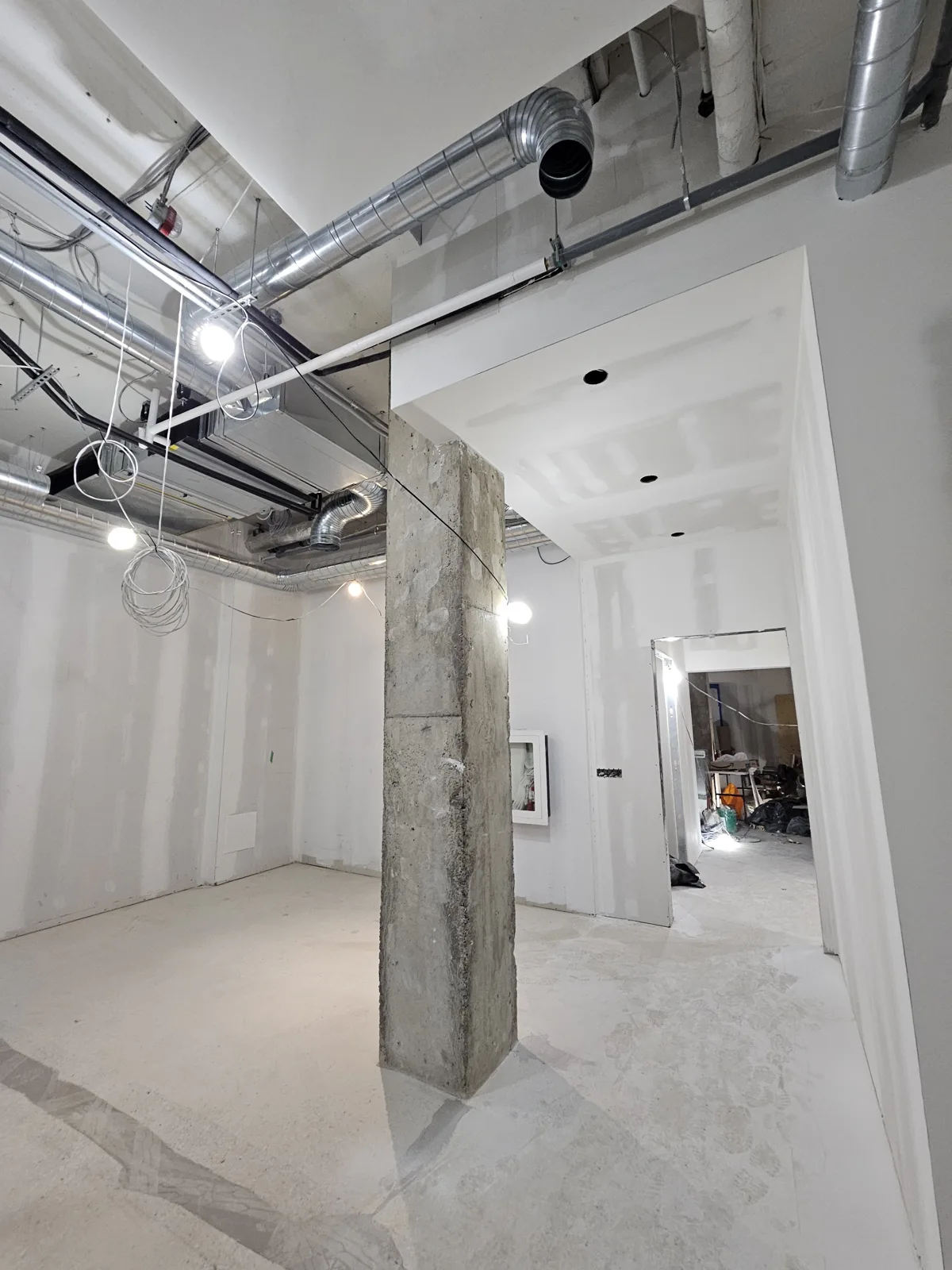 Finished commercial corridor with a concrete column and painted drywall walls in Noblesville, IN