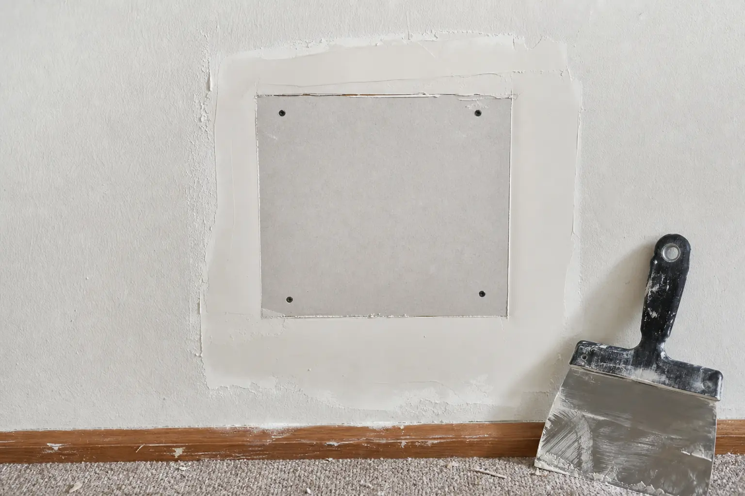 Drywall and plaster repair in progress on an interior wall in a Meridian Hills home