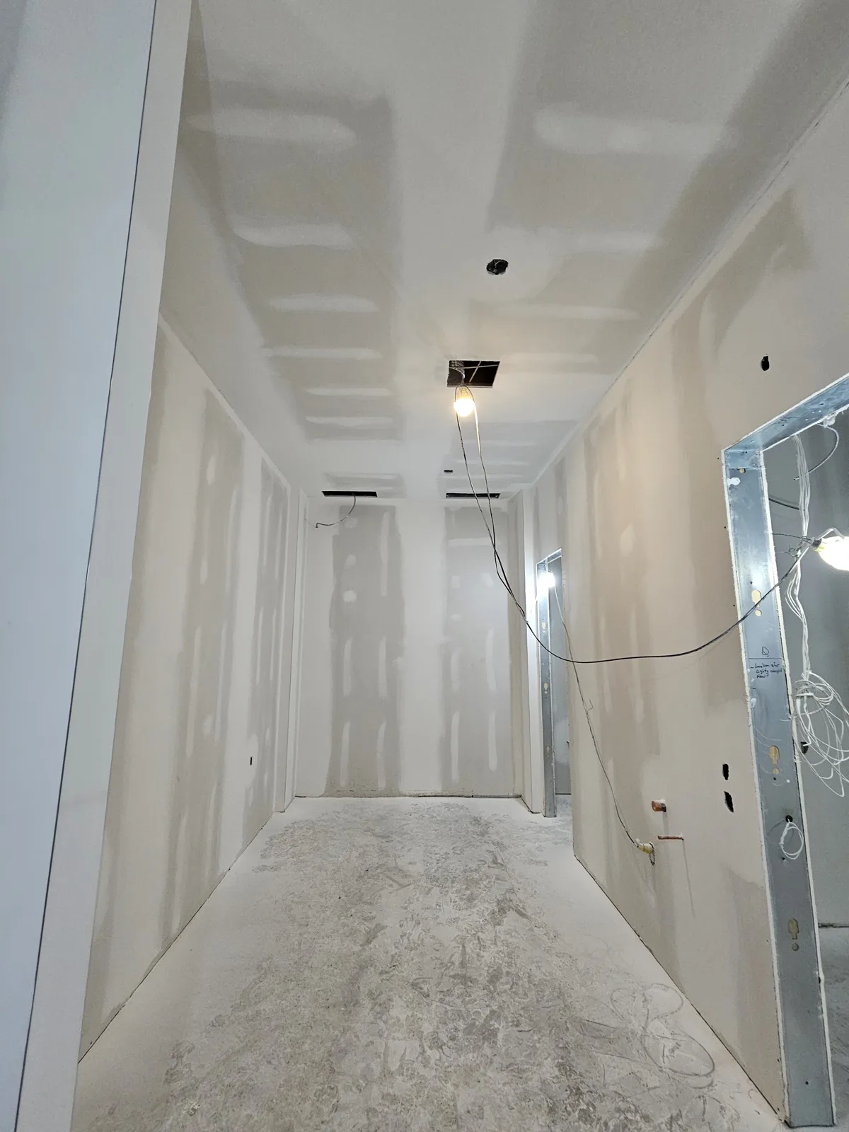 Apartment corridor in Noblesville, IN with finished drywall walls ready for primer and paint