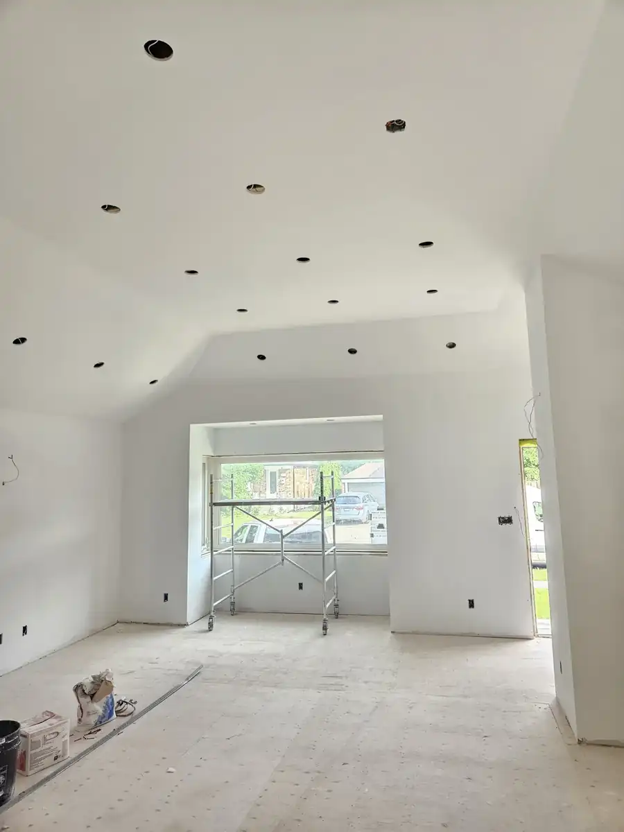 Renovated room in Noblesville, IN with new drywall and a vaulted ceiling ready for paint