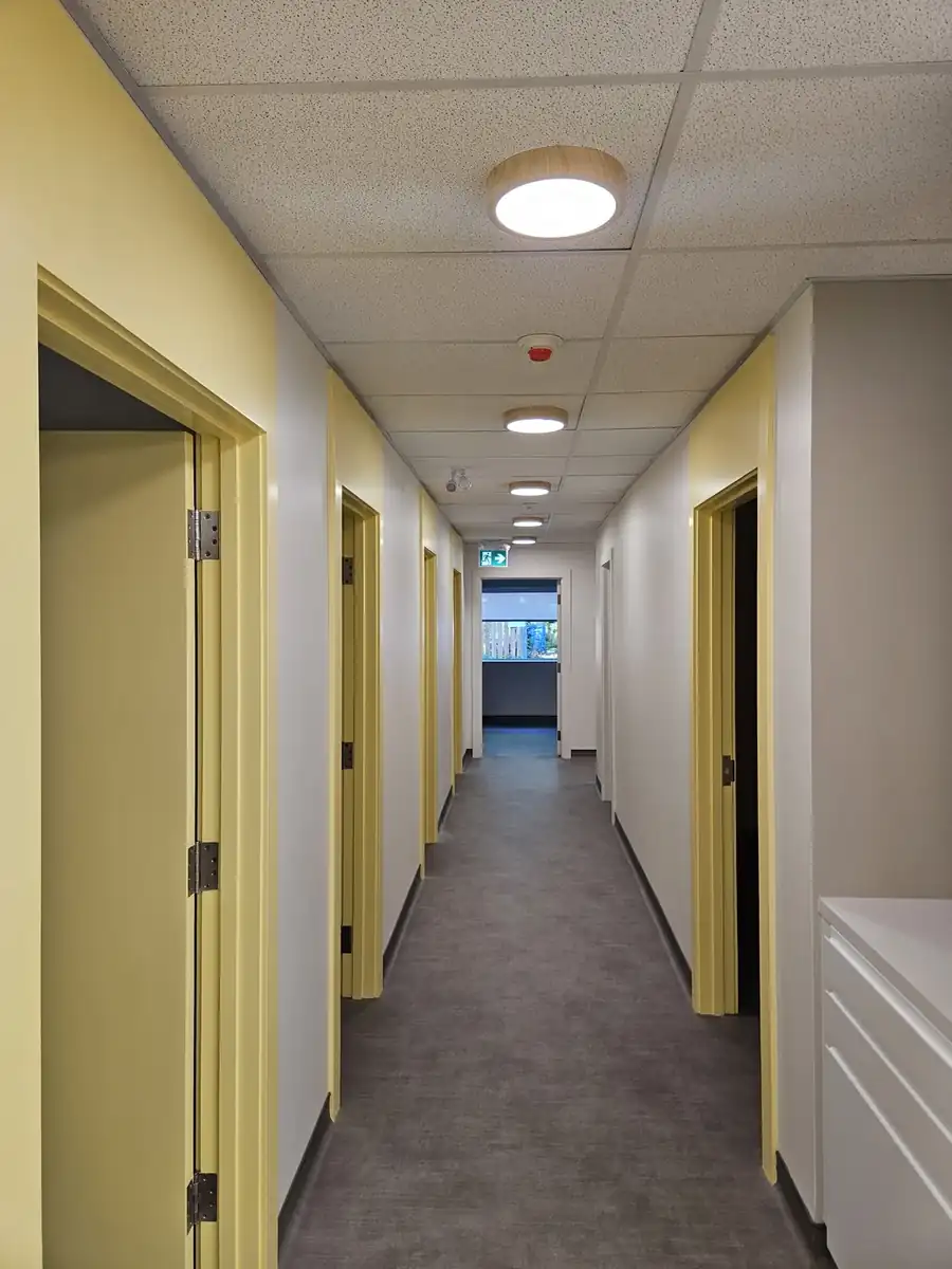 Finished commercial corridor with a suspended acoustic grid ceiling in Noblesville, IN