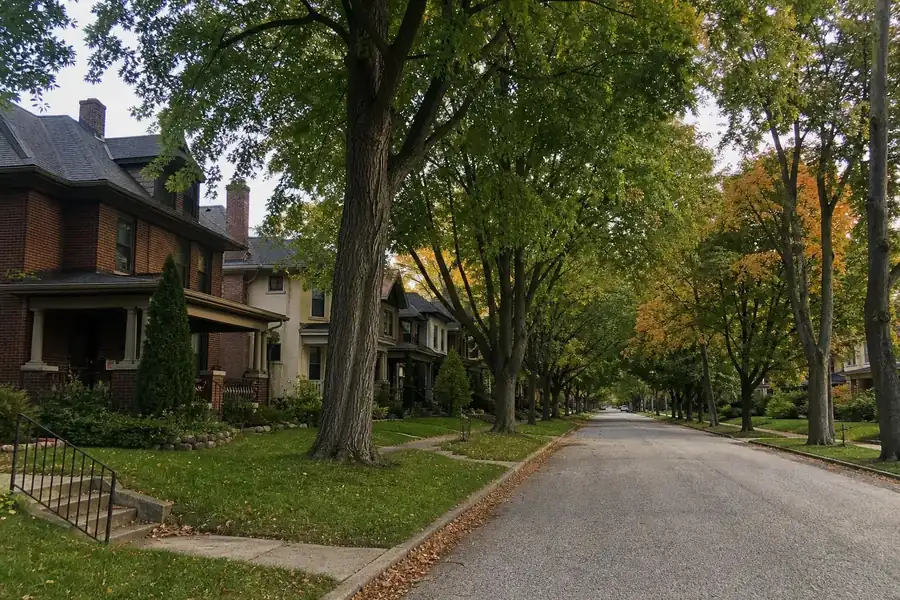 Tree-lined street of older brick two-story homes on the north side of Indianapolis