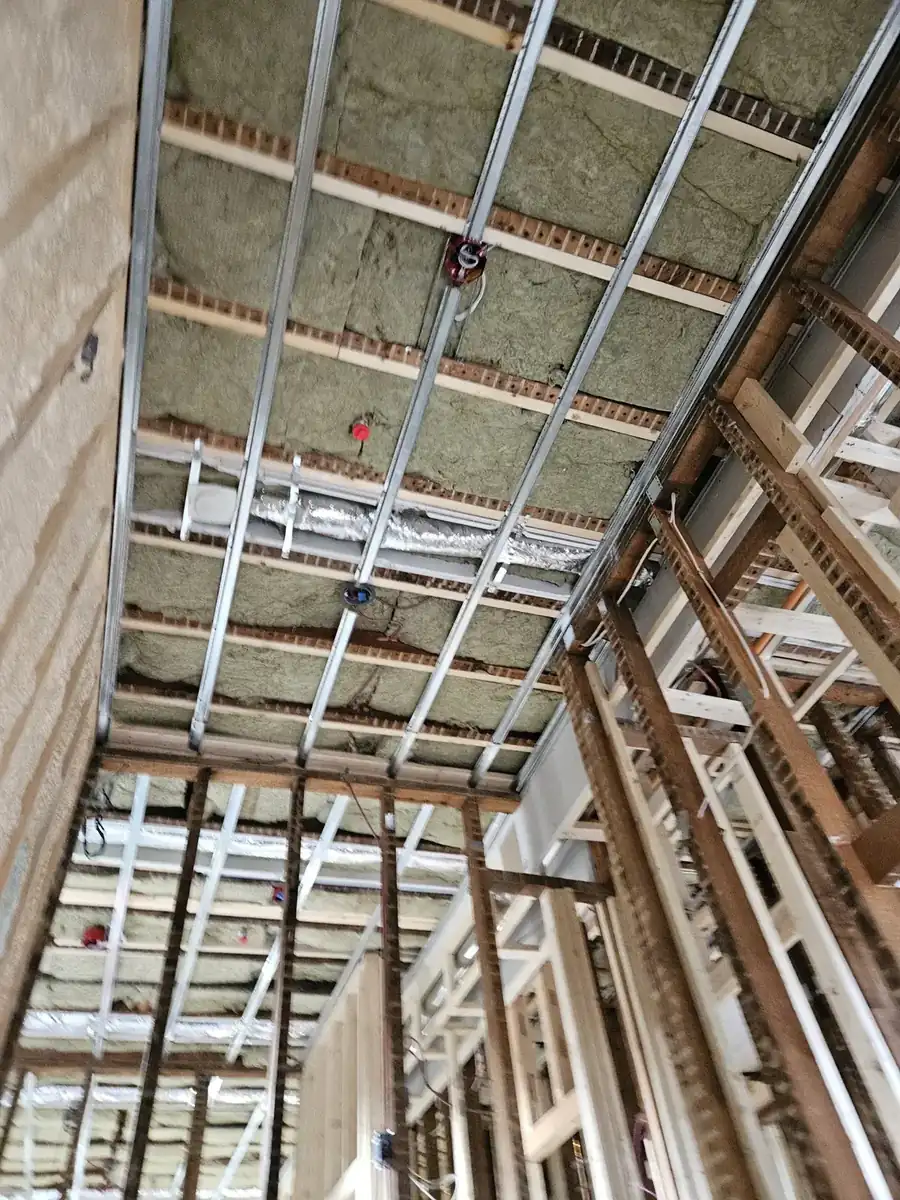 Ceiling framed with metal resilient channel over mineral wool insulation for sound isolation in Noblesville, IN
