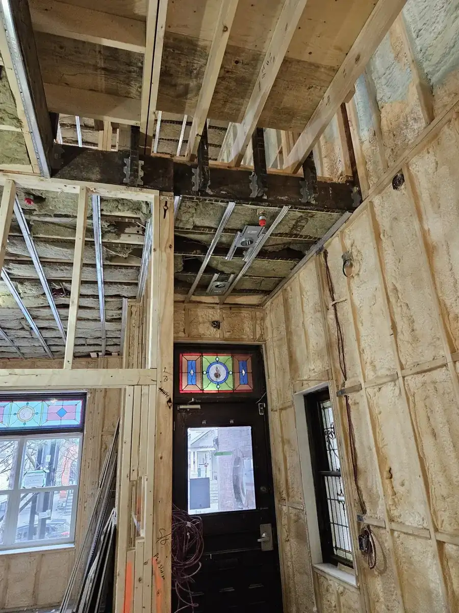 Gutted interior of an older Noblesville, IN home with exposed framing and new insulation during restoration