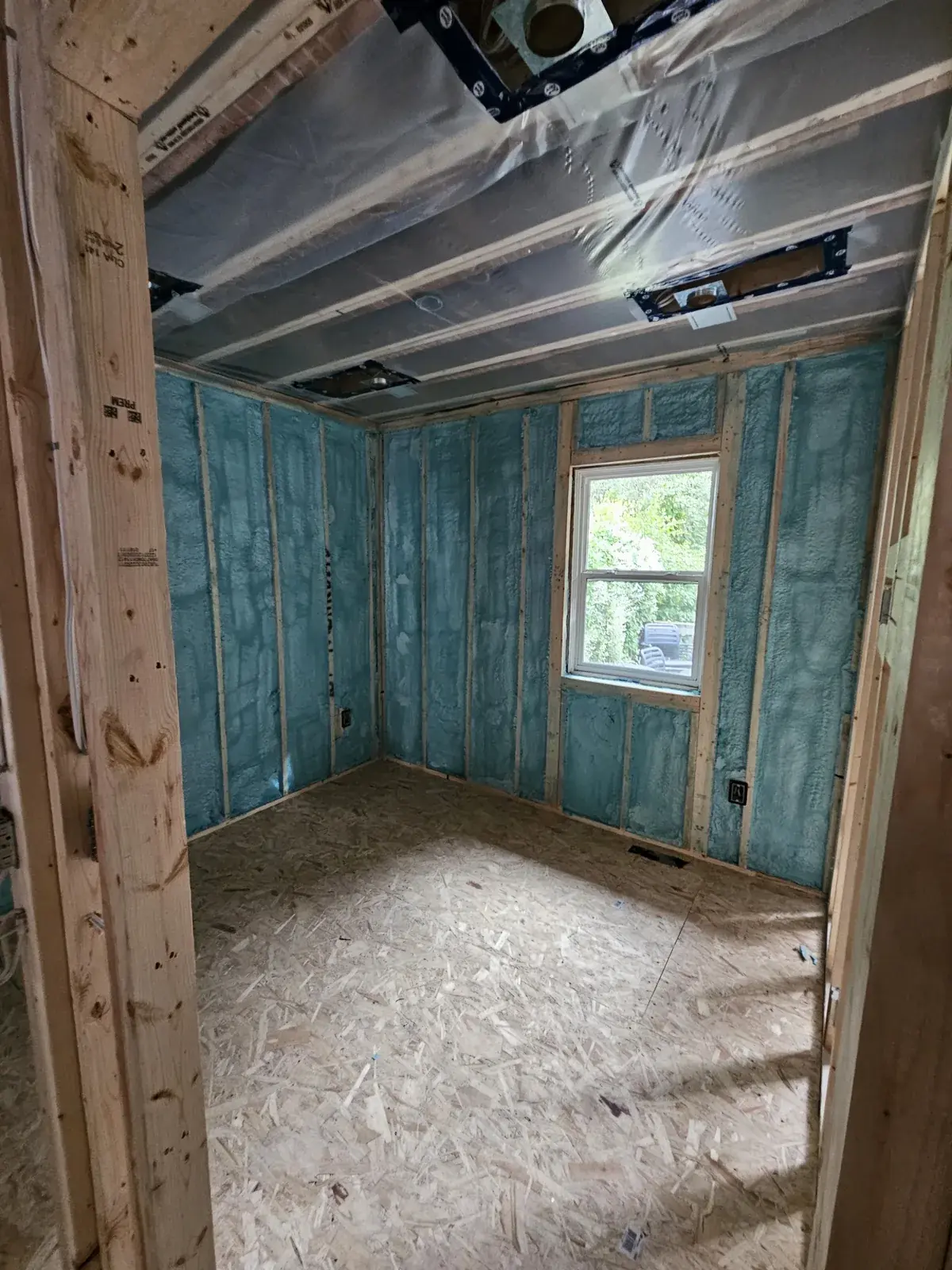 Room in a Cicero home with closed-cell spray foam insulation applied between wall studs